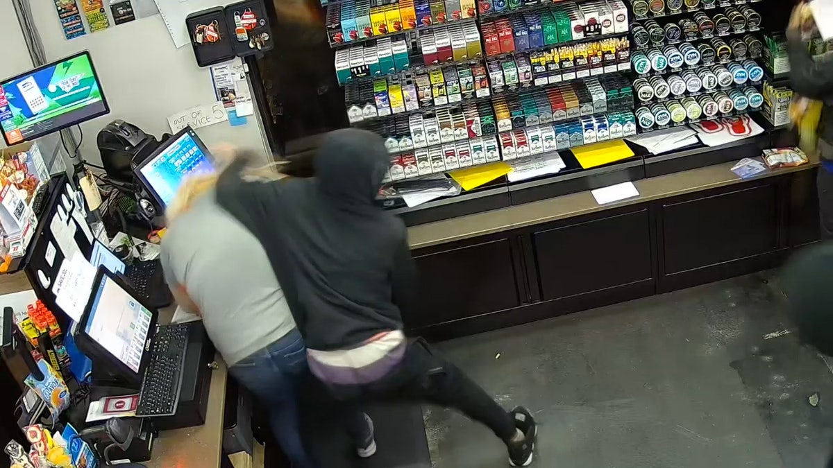 Surveillance video shows black-clad suspect beating woman in gas station