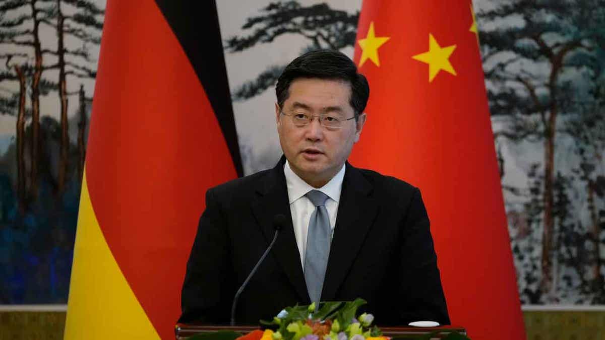 Qin Gang, Chinese foreign minister at press conference with German, Chinese flags behind him