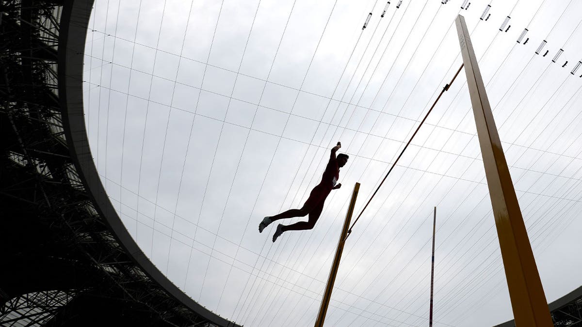 man competes in pole vault