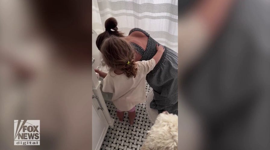 Toddler comforts her pregnant mom who's enduring months of morning sickness