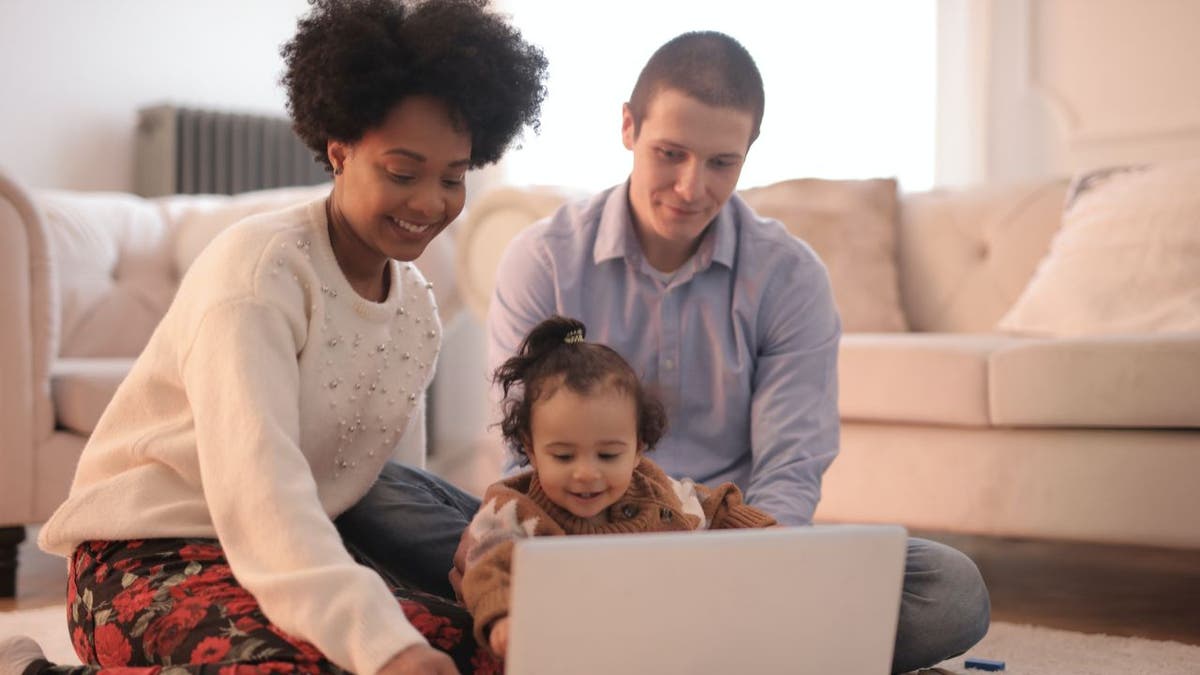 daughter with parents looks at laptop