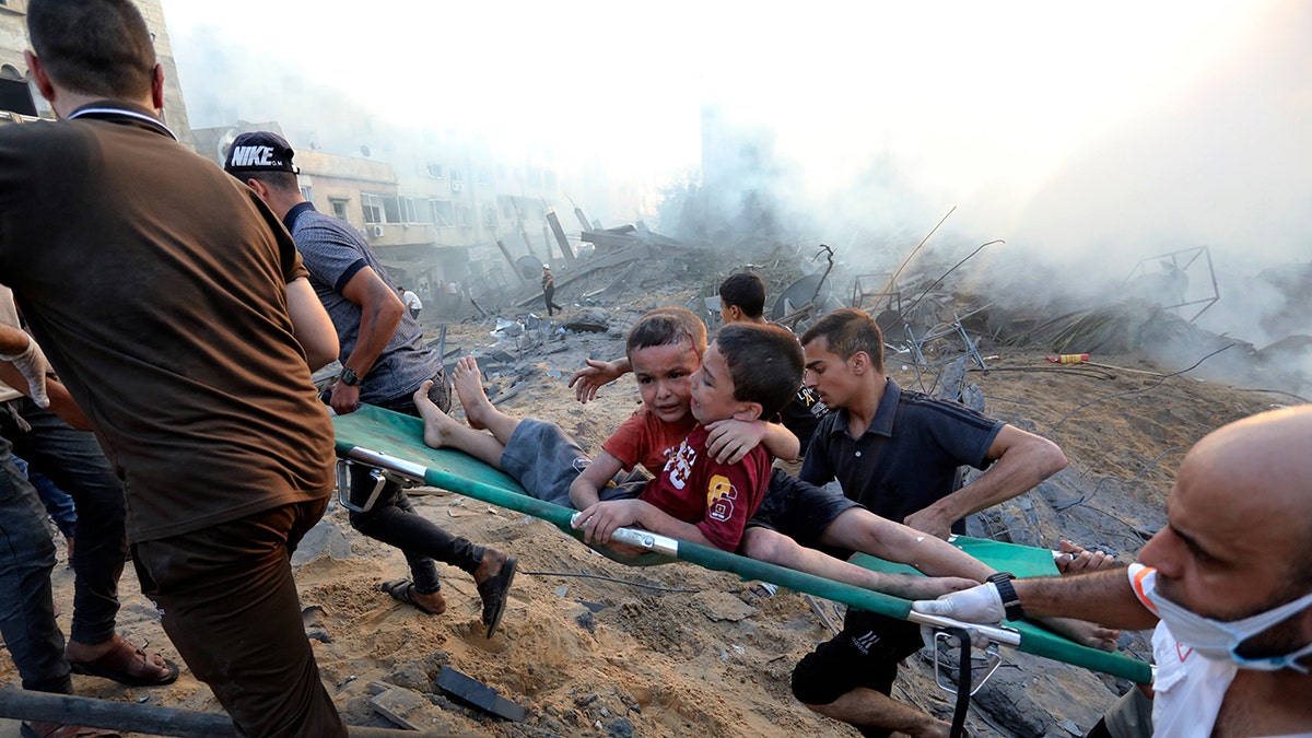 Wounded Palestinian boys are carried on a stretcher after an Israeli airstrike hits Gaza neighborhood