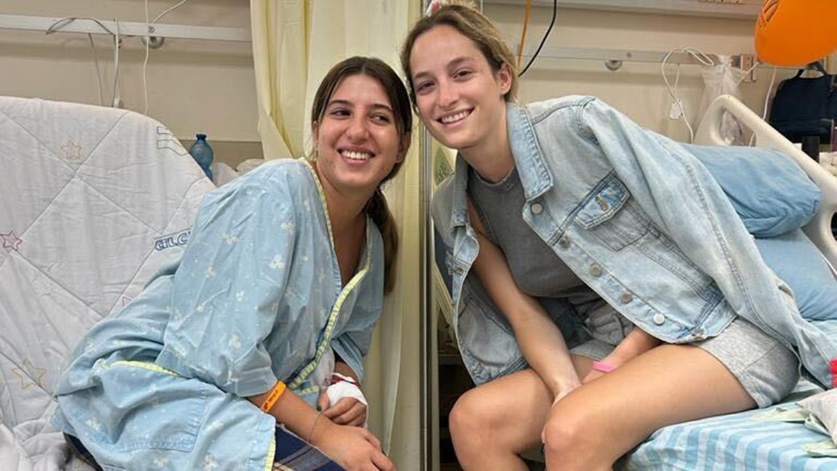 Noa Ben Artzi and Michele smiling, sitting on hospital beds