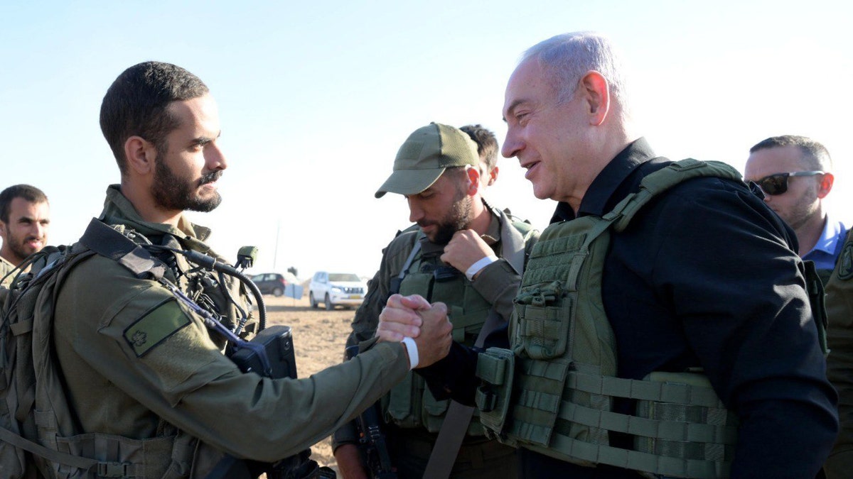 Netanyahu shakes hands with a soldier