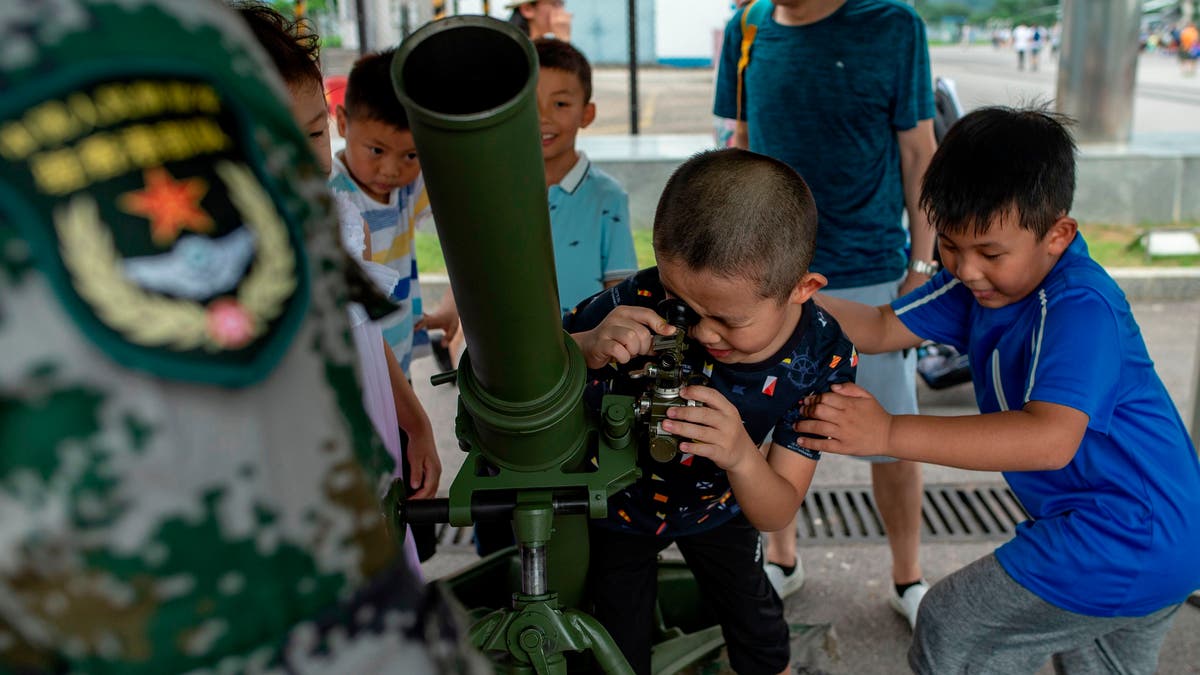 child looks through scope of missile launcher