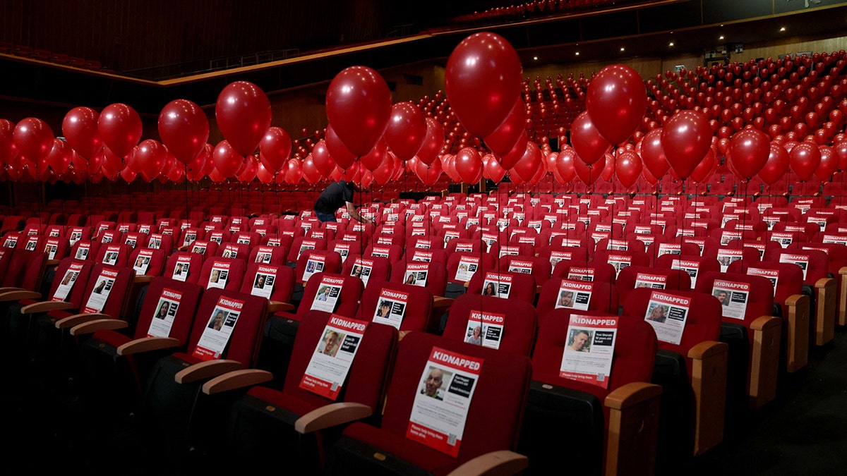 Red balloons over photos of missing Israelis