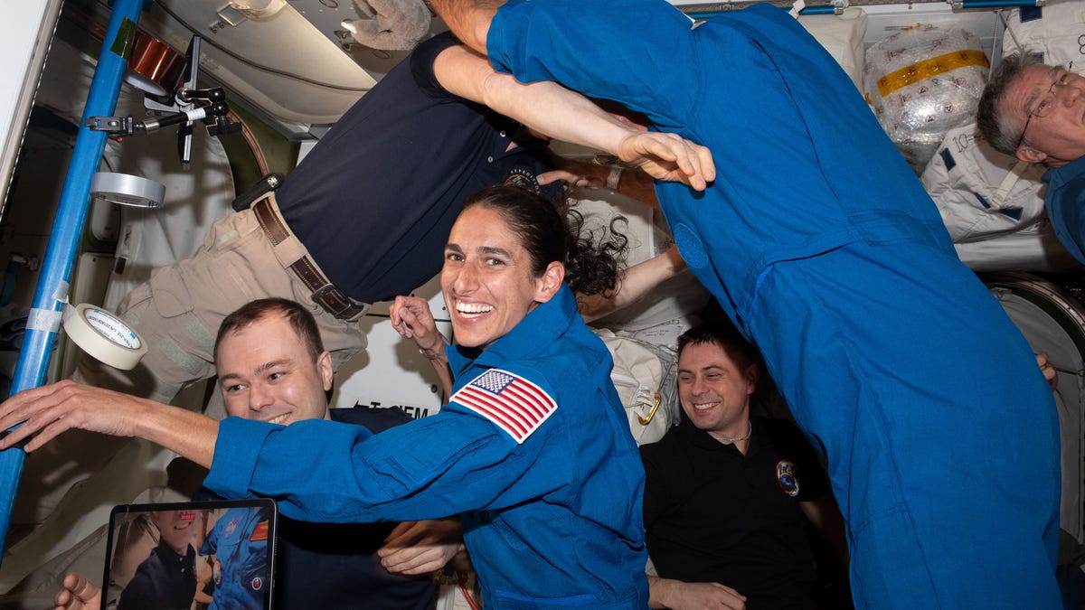 NASA astronaut Jasmin Moghbel surrounded with floating crewmates aboard the ISS