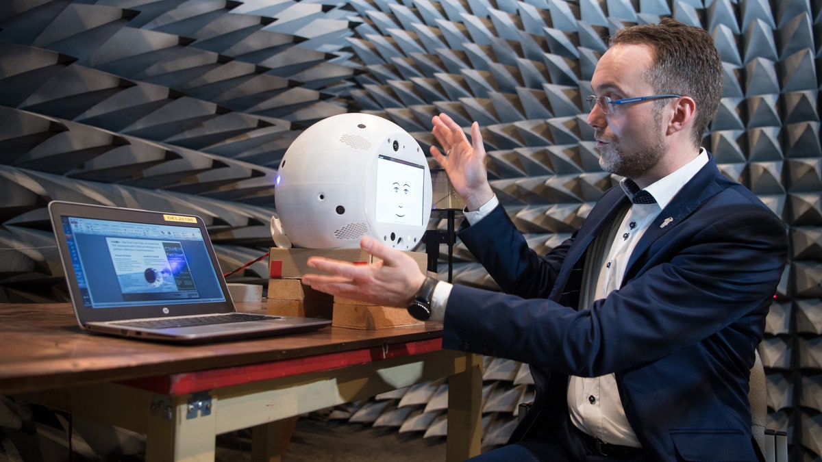 Scientist holds CIMON the artificial intelligence space companion in Earth lab