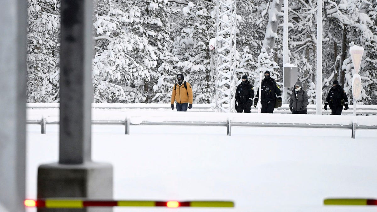Finnish Border Guards escorting two migrants