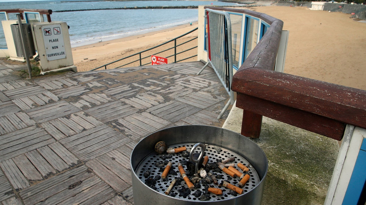 Cigarette-filled public ashtray at French beach