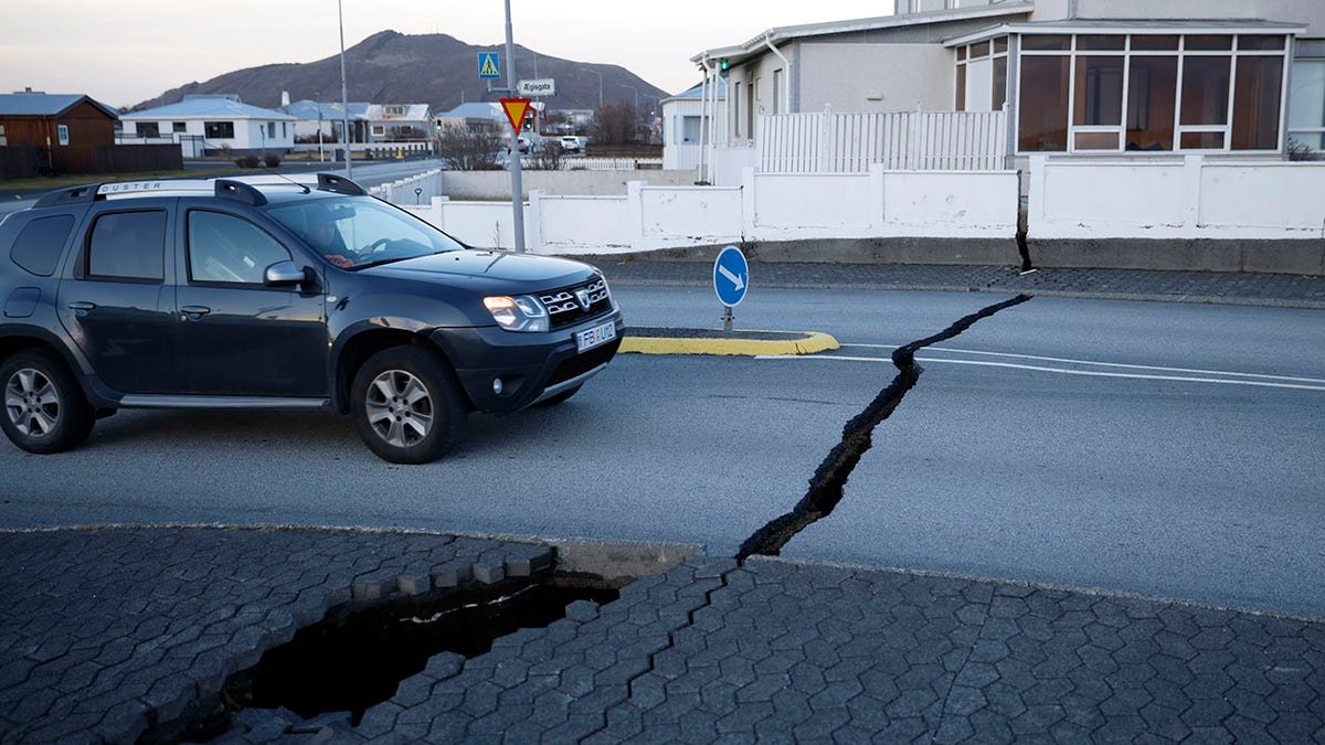 Car drives on cracked road in Iceland