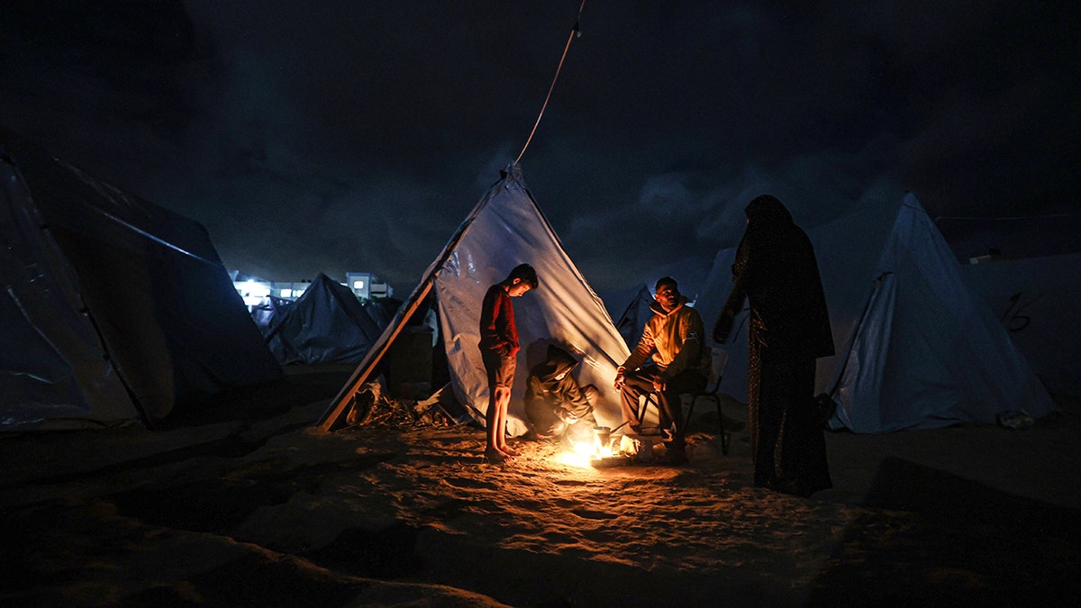 Palestinians near a camp fire
