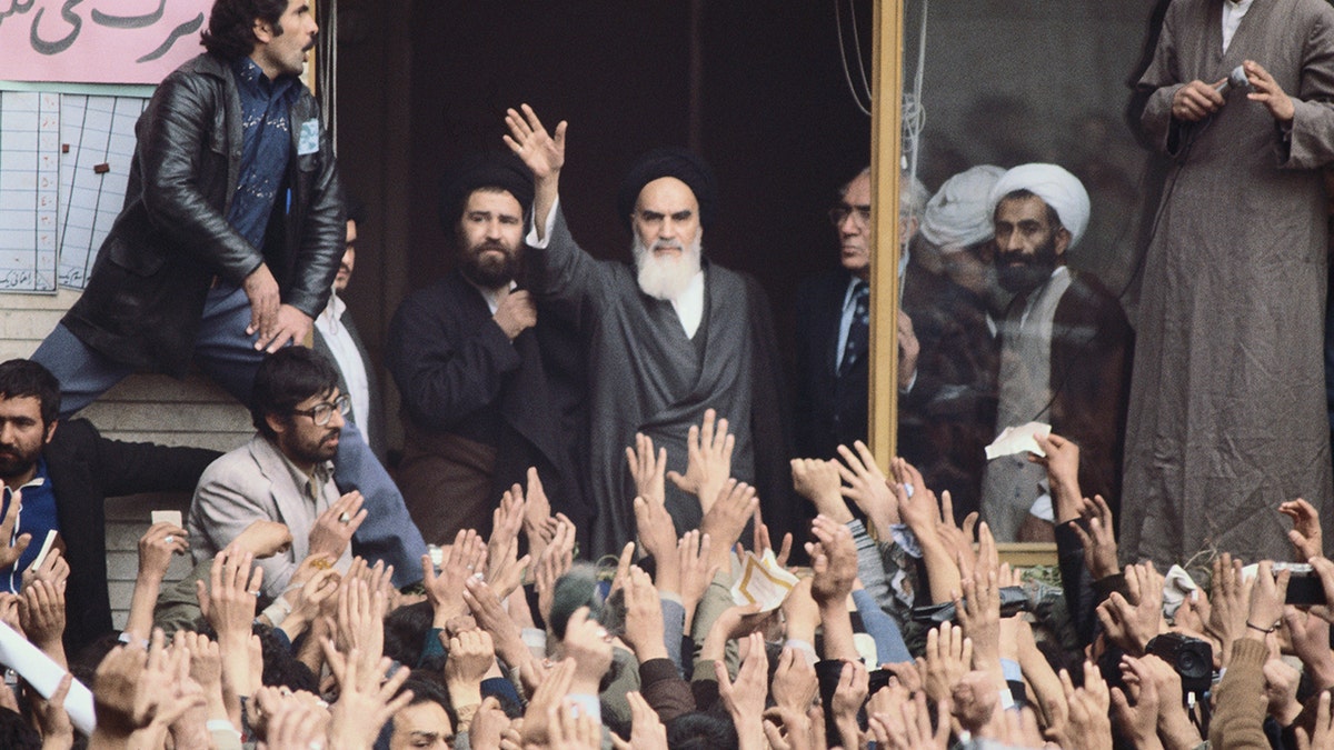 Ayatollah Khomeini waves to a crowd