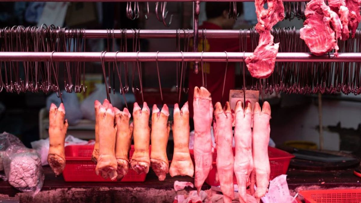 Pig feet hang inside a meat stall in Hong Kong