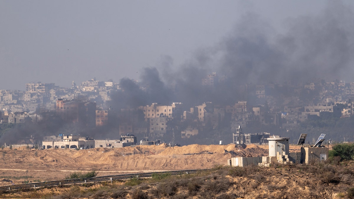 Dark, grey smoke surrounds destroyed homes and buildings of central Gaza