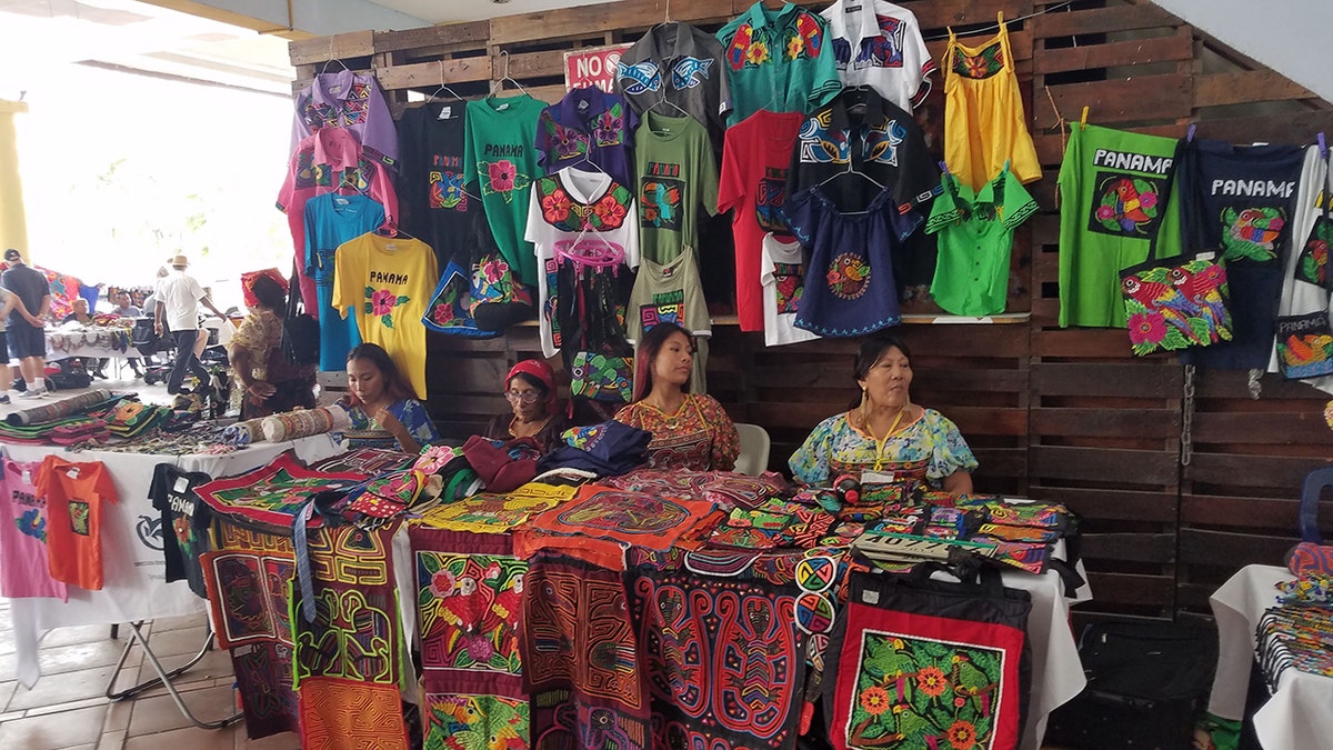 Panamanian woman sitting in front of tourist merchandise trying to sell to tourists
