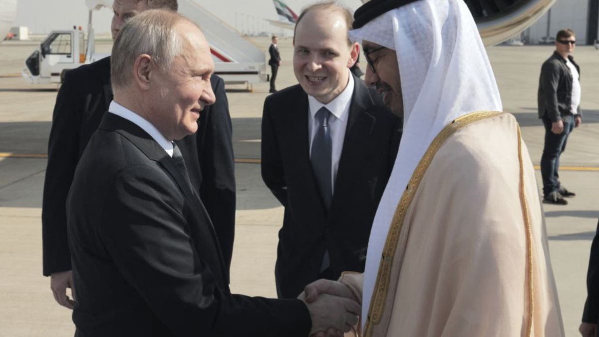 Russia's President Vladimir Putin shaking hands with UAE Foreign Minister Sheikh Abdullah Bin Zayed upon arrival at the airport in Abu Dhabi