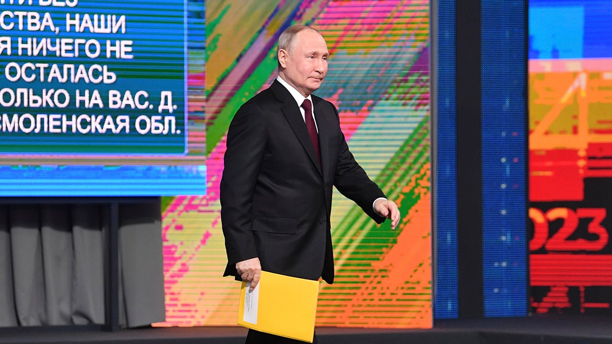 Putin walking with a folder in his hand