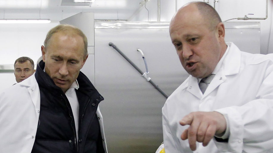 Businessman Yevgeny Prigozhin shows Russian Prime Minister Vladimir Putin
