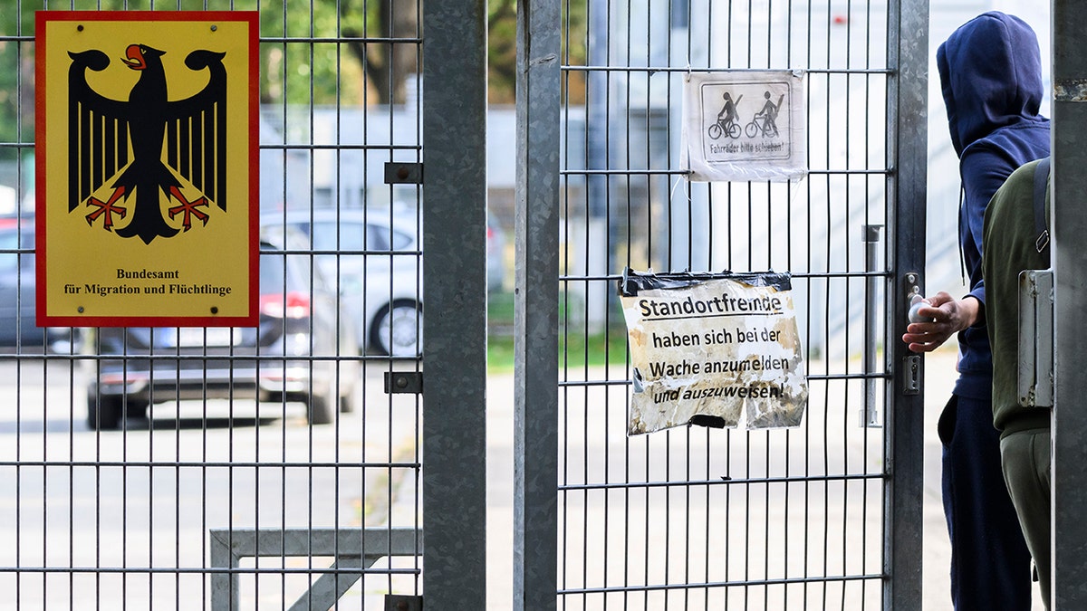 Refugee in Germany entering through gate near Migration and Refugee office