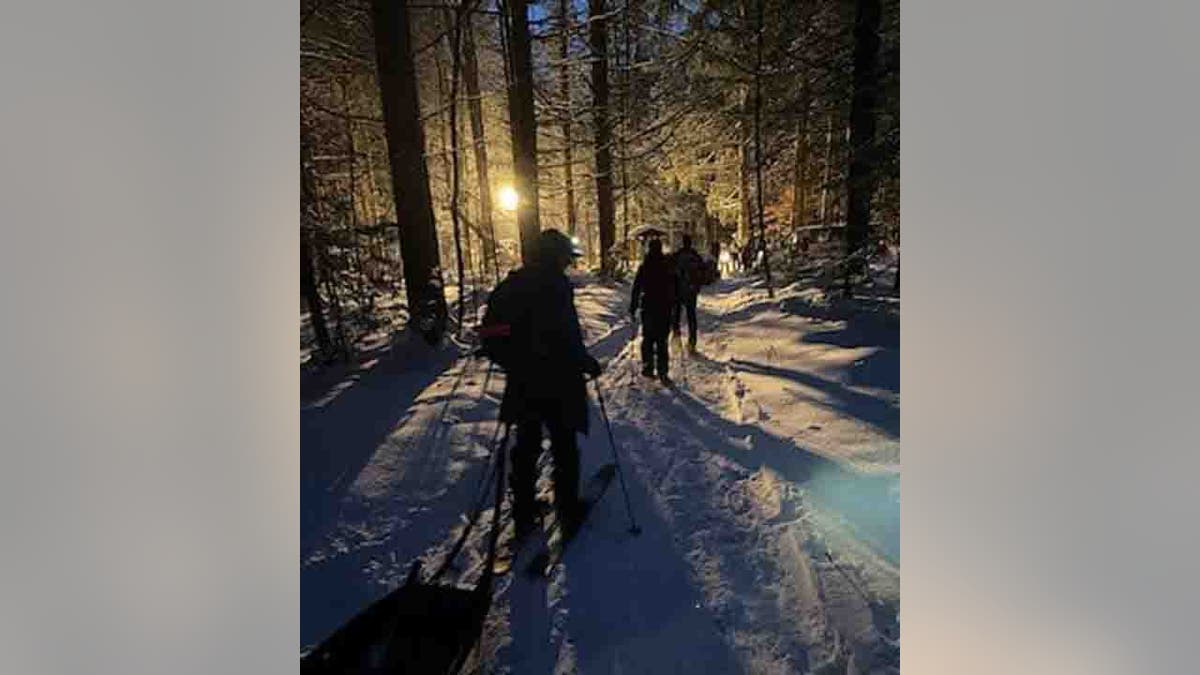 rescuers and skiers hiking through snow