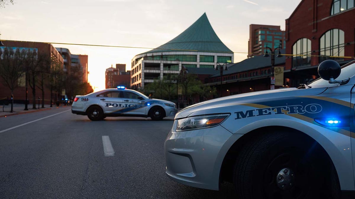Police cars and cordon tape block Main Street near the Old National Bank after a mass shooting in Louisville, Kentucky.