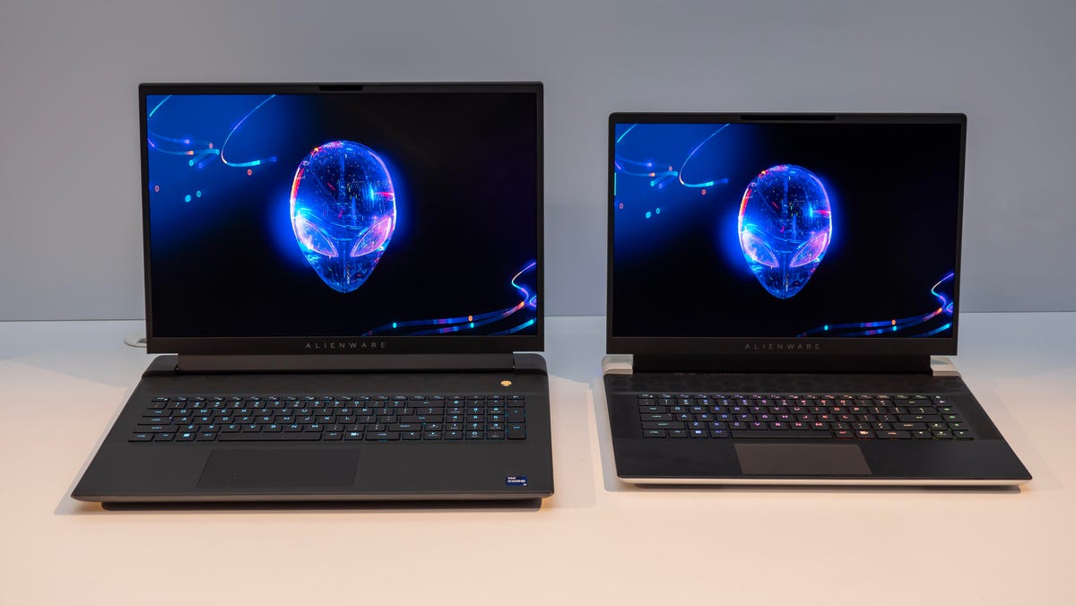 The Alienware m18 R2 and x16 R2 sitting next to each other open and facing forward on a white table with a gray background.