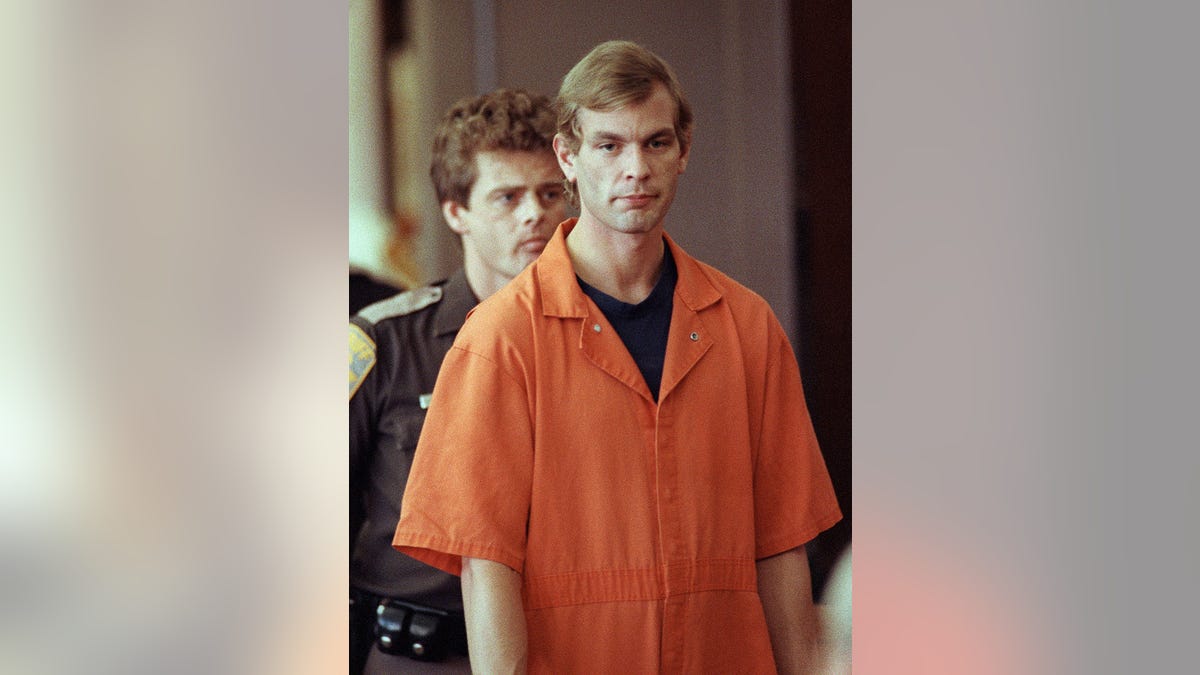 A close-up of Jeffrey Dahmer in an orange jumpsuit in court