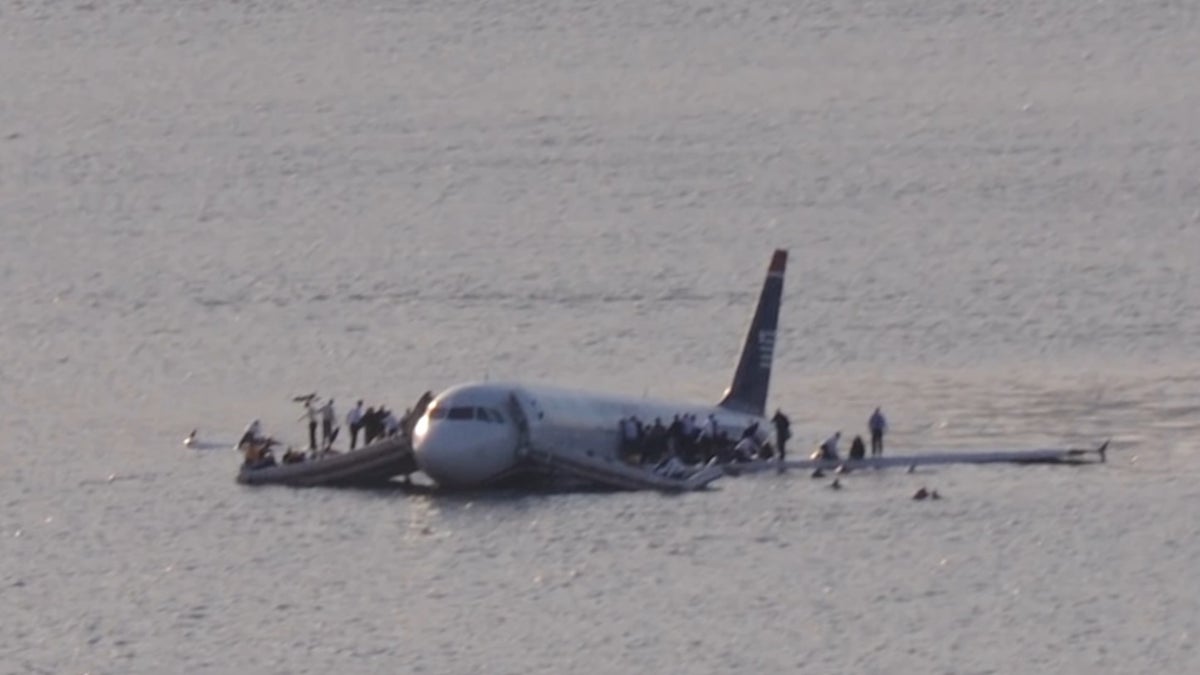 Airways Flight 1549 resting in the Hudson River as passengers stood on the wings waiting to be rescued