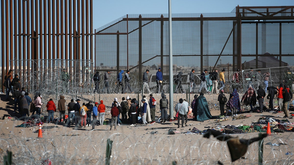 Migrants waiting at the border wall