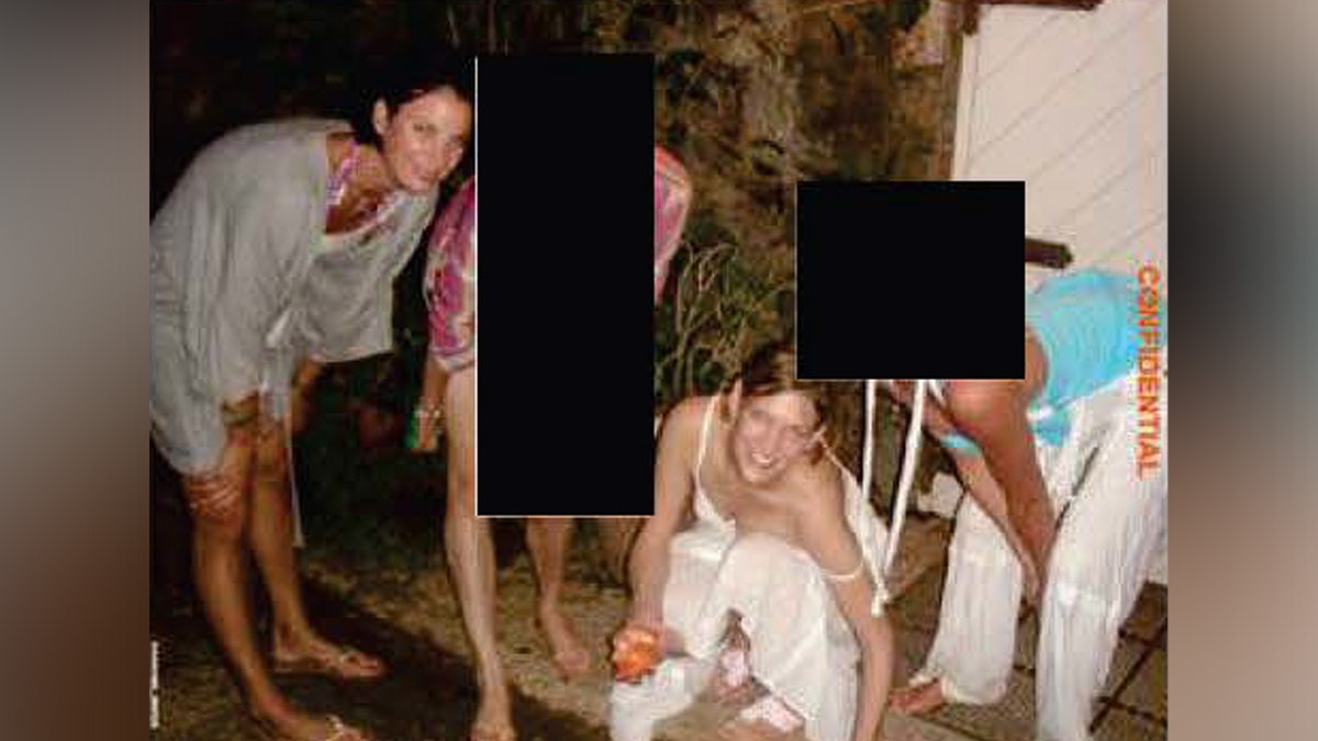 A partially-redacted evidence photo shows various girls smiling for a picture on Jeffrey Epstein's Little St. James Island