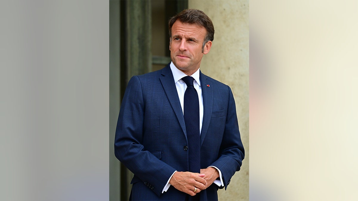 French President Emmanuel Macron standing outside.