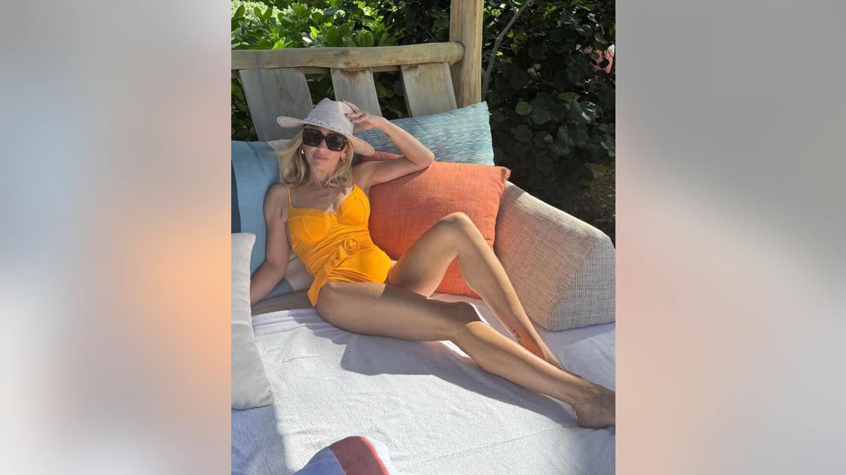 sarah michelle gellar in orange swimsuit laying on a sunbed