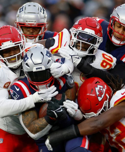 Chamarri Conner, Charles Omenihu and Nick Bolton of the Kansas City Chiefs tackle New England Patriots running back Ezekiel Elliott on Sunday, December 17. The Chiefs won 27-17.