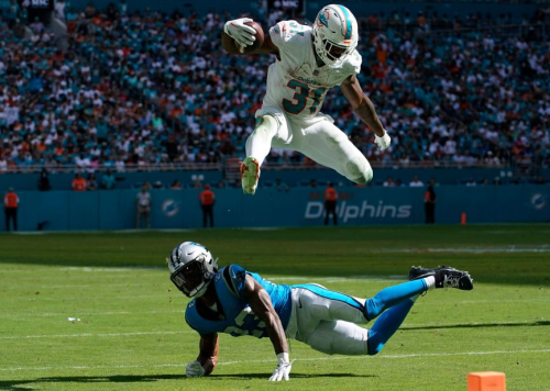 Miami Dolphins running back Raheem Mostert jumps over Carolina Panthers cornerback CJ Henderson. Mostert had two touchdowns during the Dolphins' 42-21 victory.