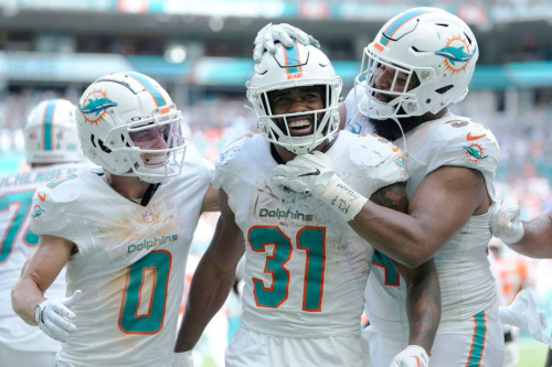 Miami Dolphins running back Raheem Mostert celebrates with teammates Braxton Berrios and Christian Wilkins after scoring one of his four touchdowns during the Dolphins' landslide victory over the Broncos on September 24. 