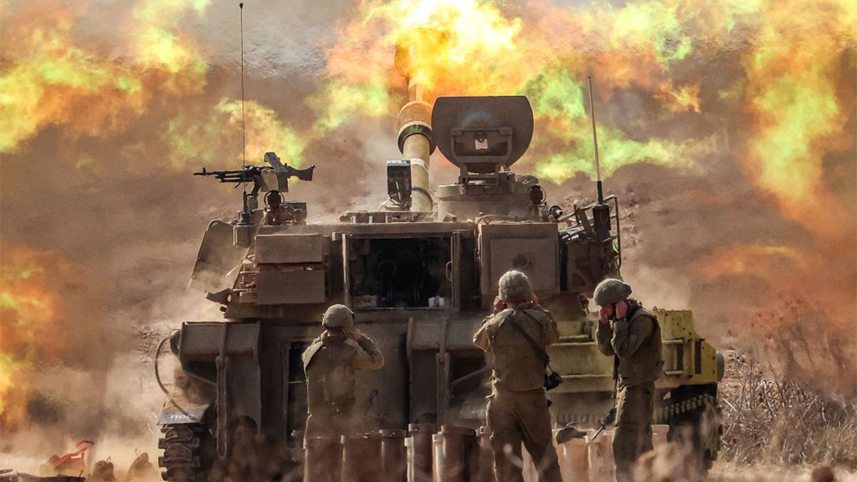 An Israeli army M109 155mm self-propelled howitzer fires rounds near the border with Gaza in southern Israel on October 11, 2023.
