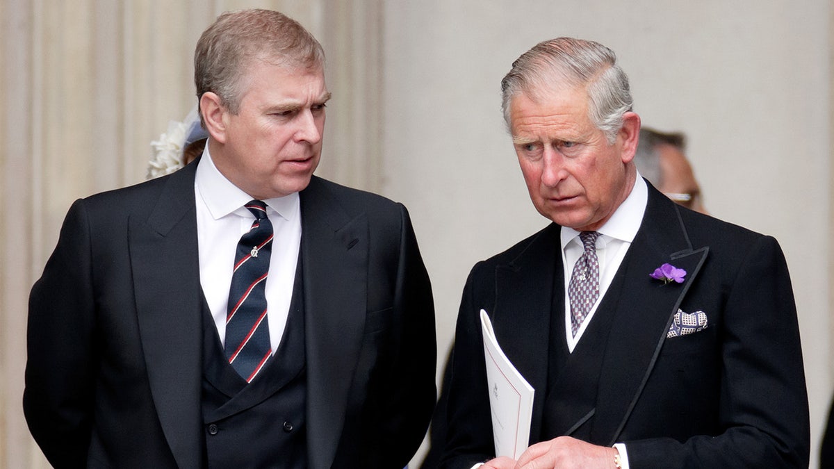 Prince Andrew talking sternly to a serious King Charles
