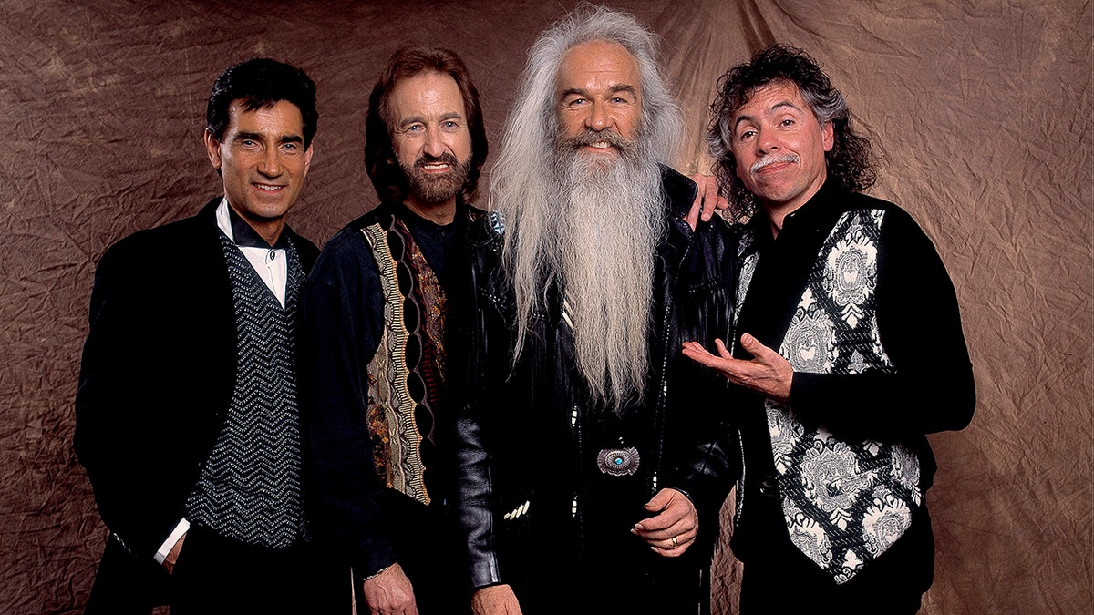 A picture of The Oak Ridge Boys in a variations of black clothes smiling for a photo