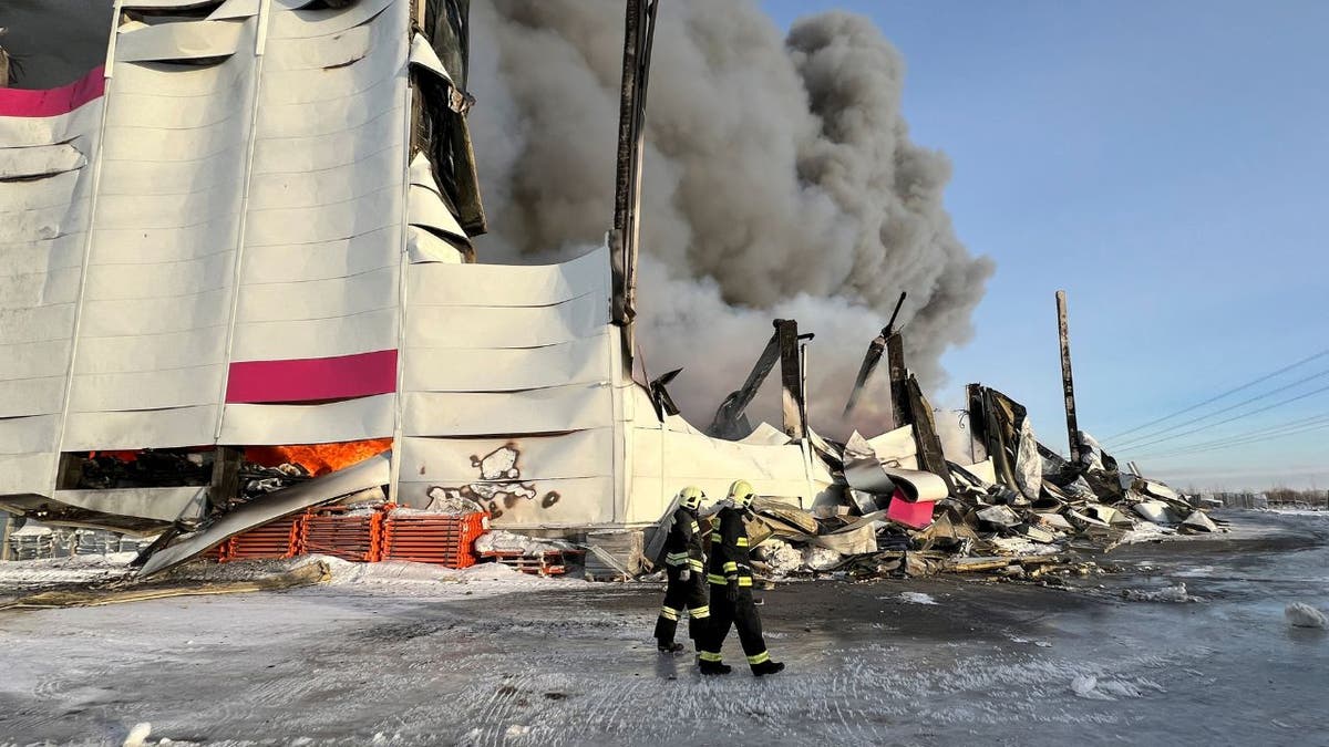 Firefighters outside a burning warehouse in Russia