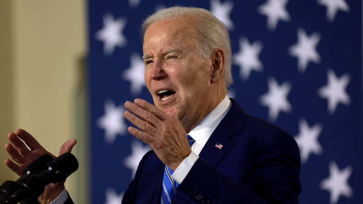 Joe Biden motioning with hands, US flag behind him