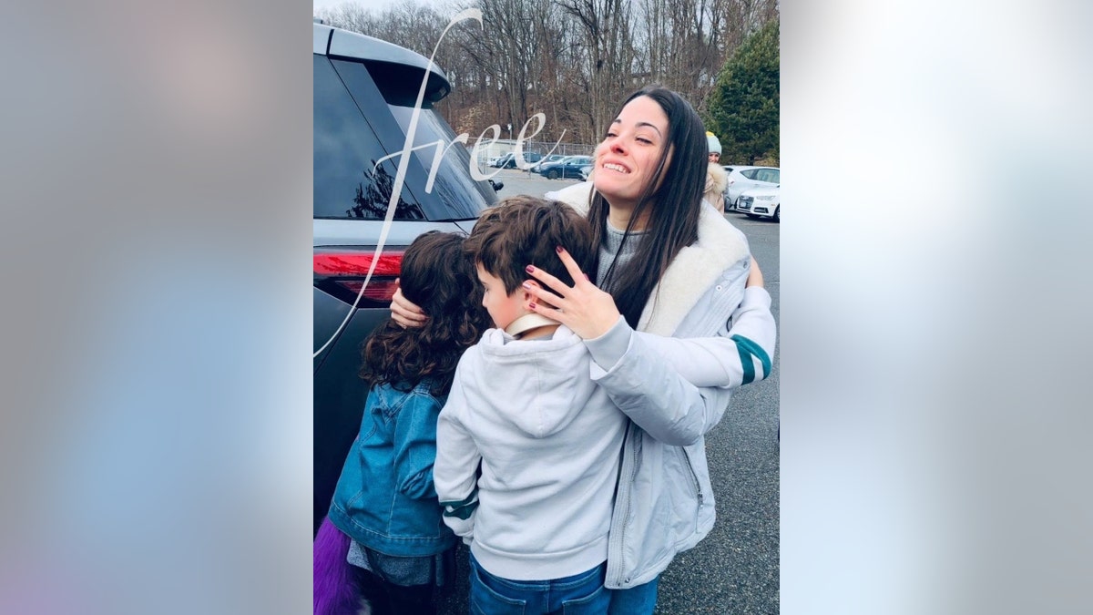 Nikki Addimando hugs her children