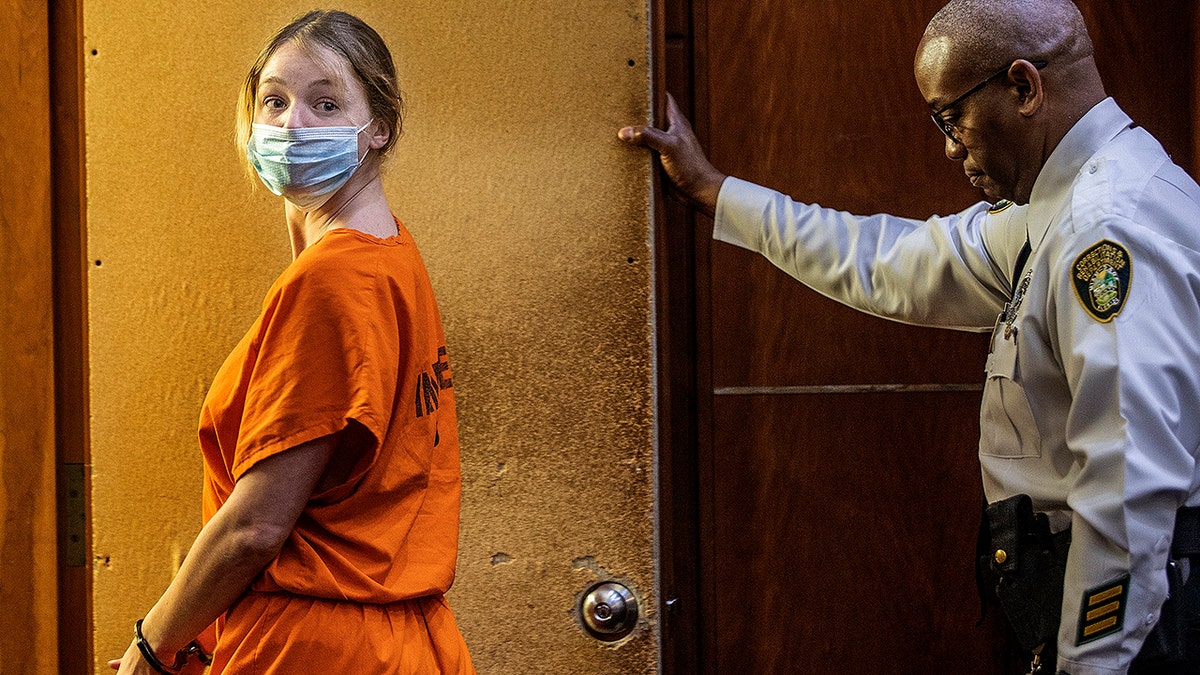 Courtney Clenney in orange jail-issue scrubs at a court hearing