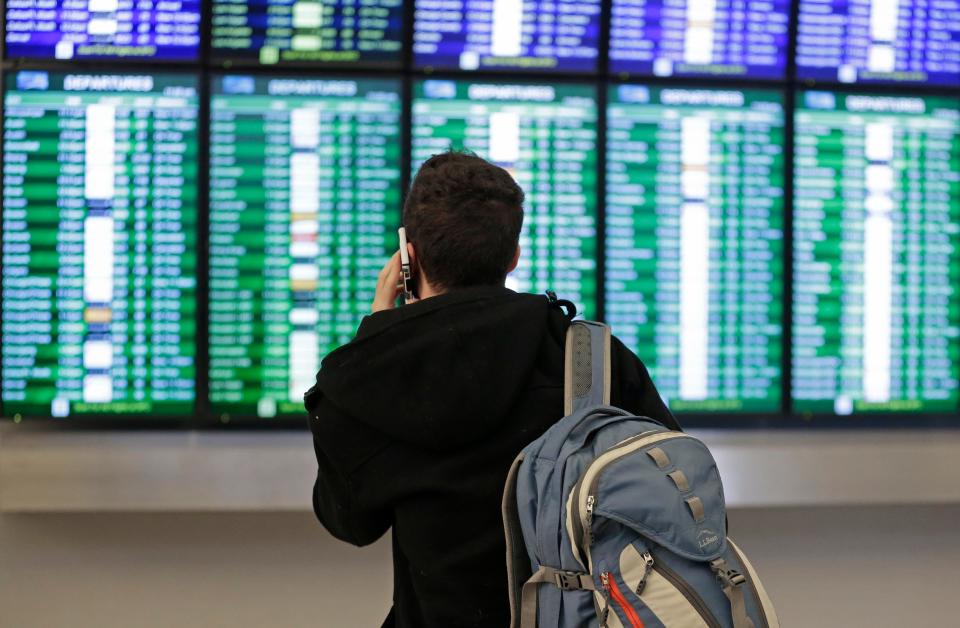 A traveler checks the arrival and departure boards at San Francisco International Airport on Jan. 22, 2016.