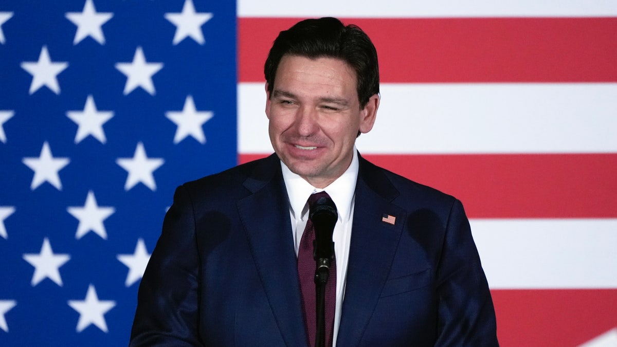 Ron DeSantis smiling in front of American flag
