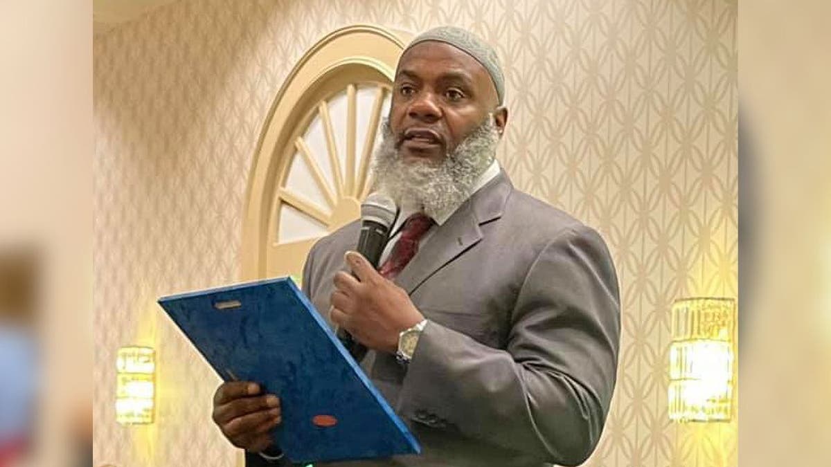 An imam speaking at an event inside a mosque