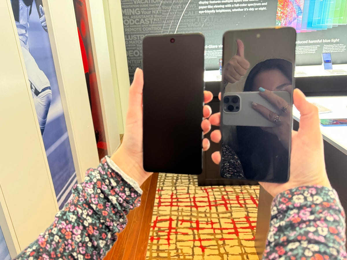The TCL 50 XL Nxtpaper 5G being held next to another TCL phone without Nxtpaper.