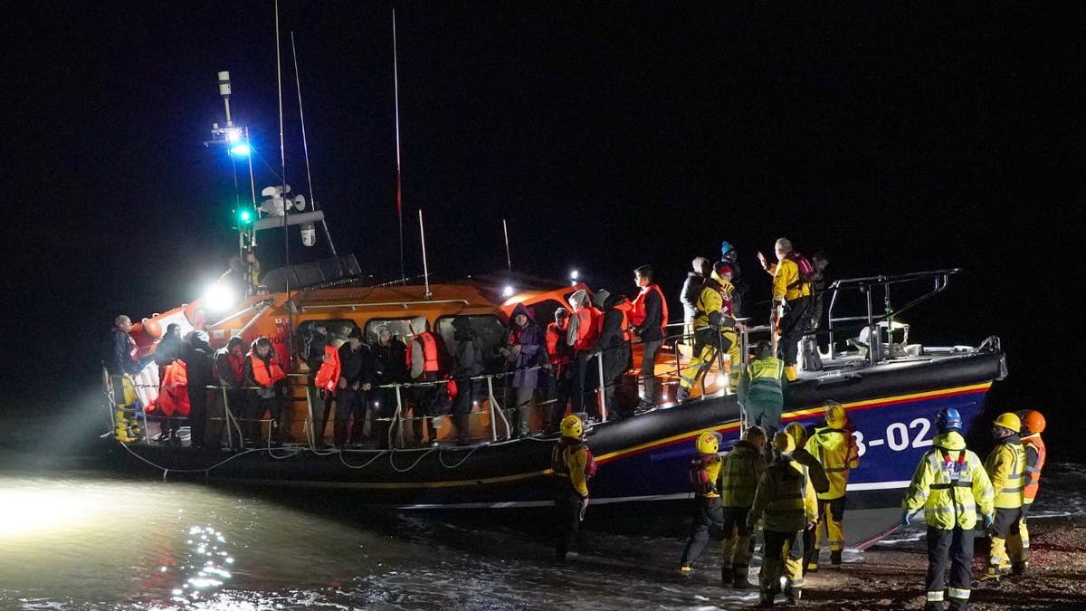 A lifeboat pulls ashore with rescued migrants