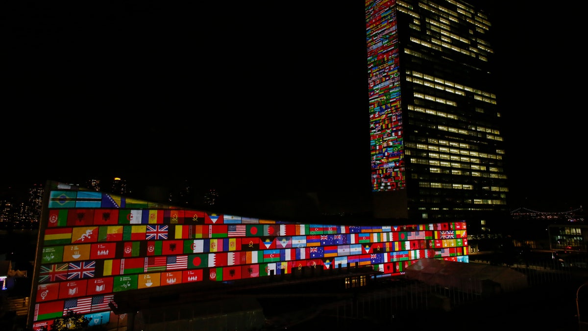 National flag projections are seen over the UN general assembly building headquarters.