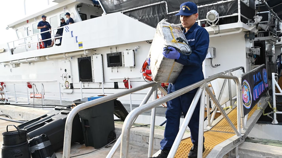 Coast Guard crew member unloading narcotics